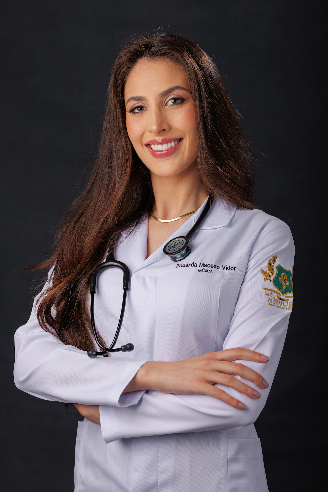 Dra. Eduarda Macedo Vidor, médica, em retrato profissional de jaleco branco.